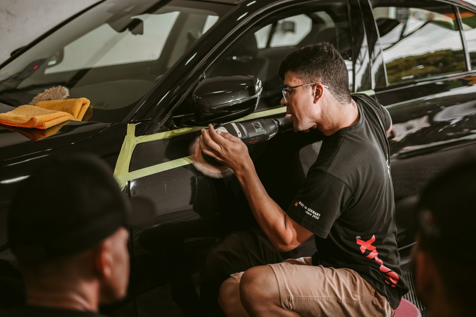 Auto detailer meticulously working on a luxury vehicle